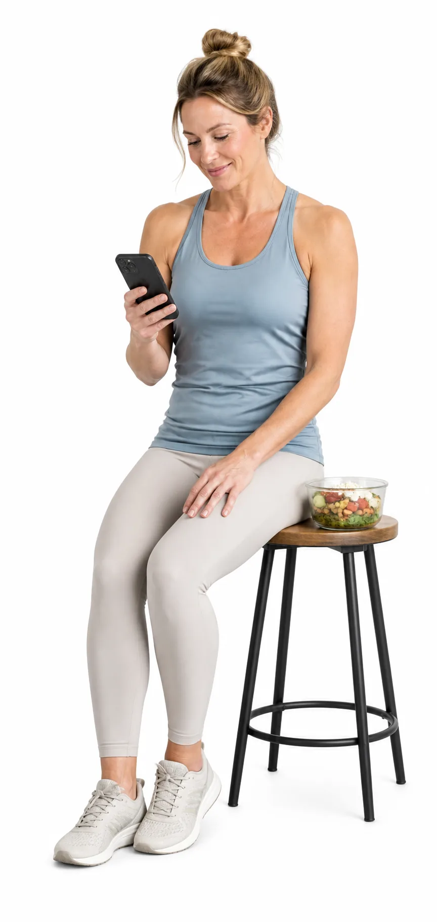 A woman reviewing her nutrition plan beside a prepared meal