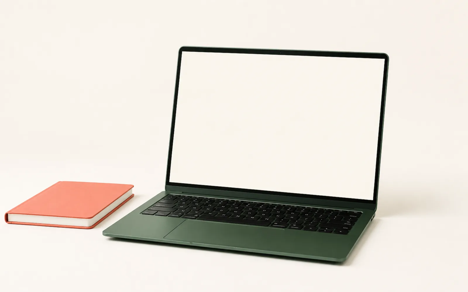 A green laptop with a coral notebook