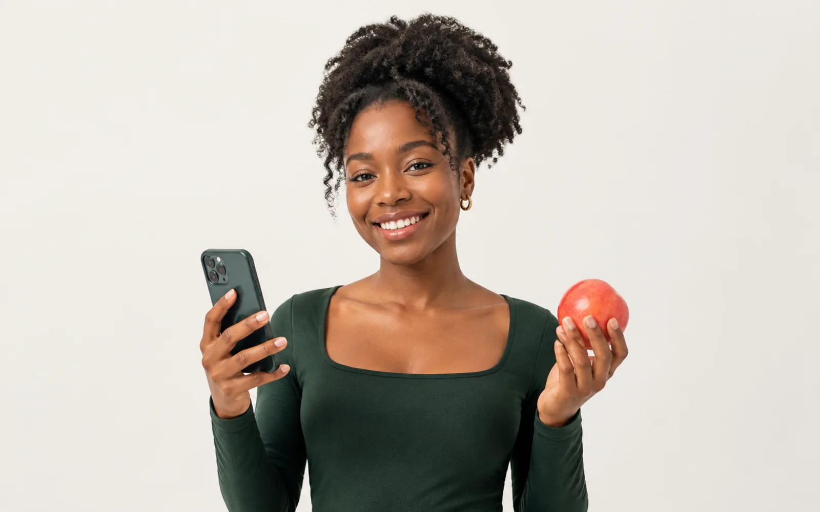A creator holding a phone and a fresh apple